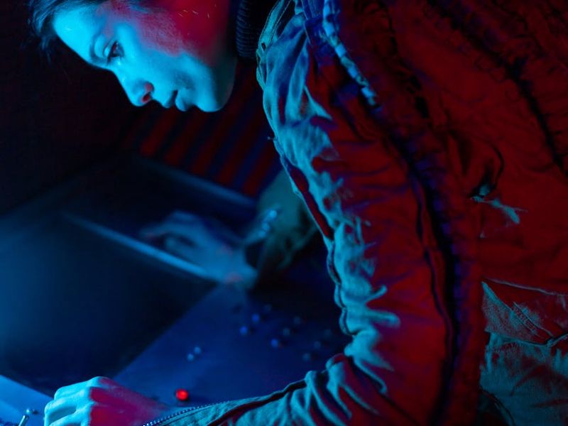 Person performing rhythmic exercises in a dark neon lit room